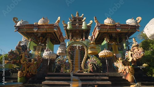 Beautiful balinese temple altar with umbrellas and dragons in Pura Melanting, Pemuteran, Bali - shot on sunny day with blue sky photo