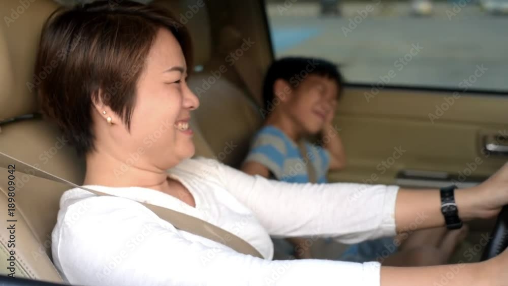 Happy mom and son in a car during journey in a traffic jam in Bangkok Happy mom and son in a car during journey in a traffic jam in Bangkok