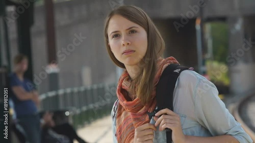 Young woman getting off train recognizing someone she knows.