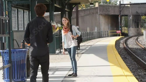 Couple meeting and embracing at train station - slow motion.