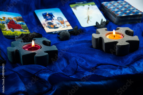 candlesticks in the form of two puzzles with tarot cards in the background on a blue background photo