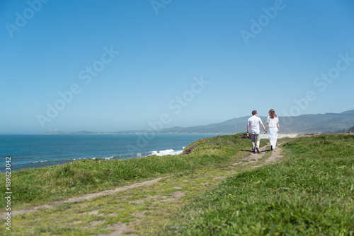 Young romantic couple walking on the trail holding hands