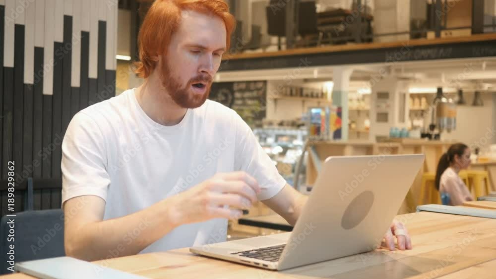 Astonished, Amazed Redhead Beard Man Working in Cafe Astonished, Amazed Redhead Beard Man Working in Cafe