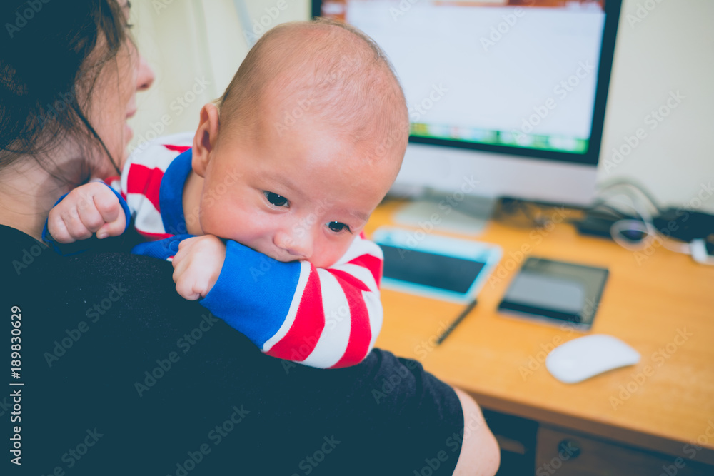 Working mother with a baby and her computer. Working mother with a baby and her computer.