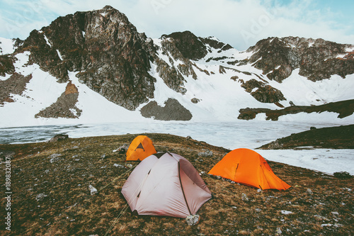 Camping tents in Mountains at frozen lake Landscape Travel Lifestyle concept adventure vacations outdoor hiking gear equipment