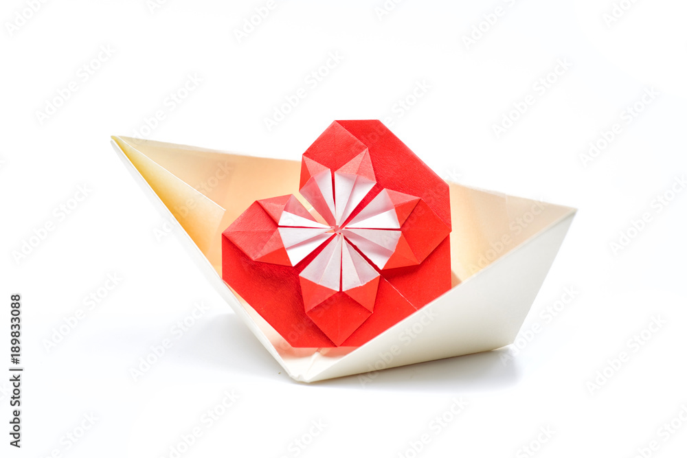 a big red origami heart in a paper yellow boat on a white background a big red origami heart in a paper yellow boat on a white background