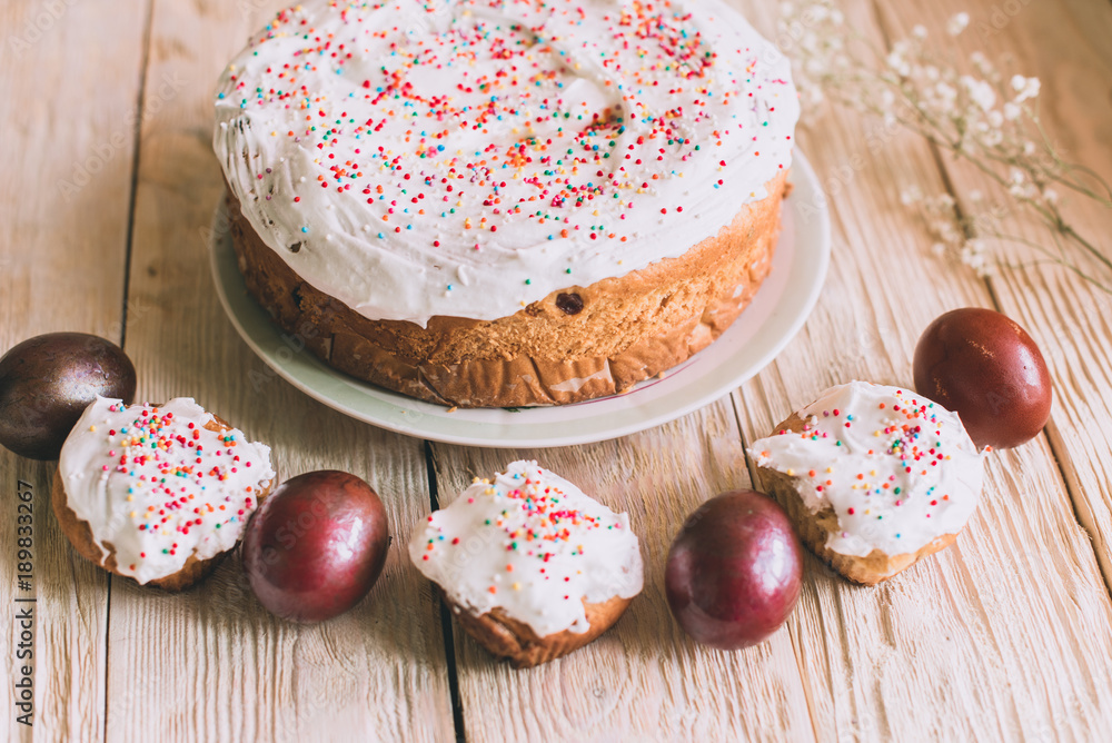 Easter table with traditional Easter cakes and Easter eggs with blossoming tree branch Easter table with traditional Easter cakes and Easter eggs with blossoming tree branch