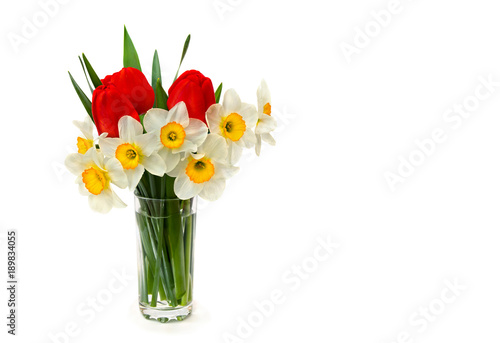 Fototapeta Naklejka Na Ścianę i Meble -  White narcissus and red tulips in glass vase on white background with space for text
