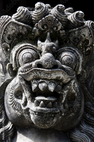 Traditional Balinese stone demon sculpture at Bali, Indonesia.
