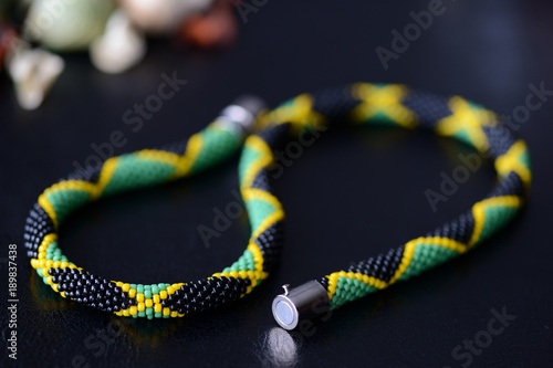 Bright beaded jamaican necklace on a dark background close up