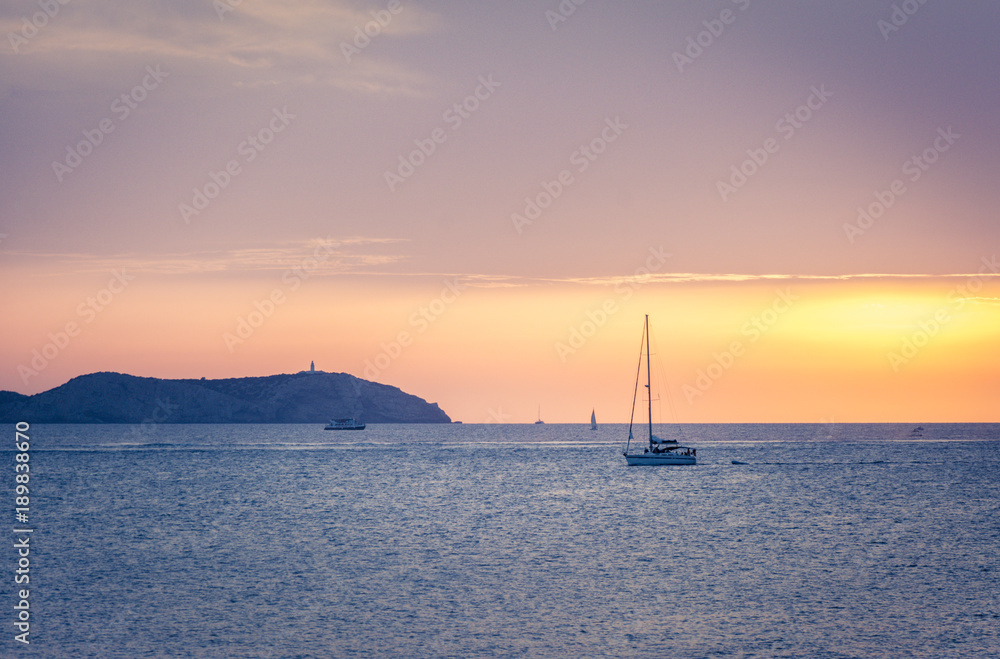 Moored sailboat at the coast of Ibiza in sunset