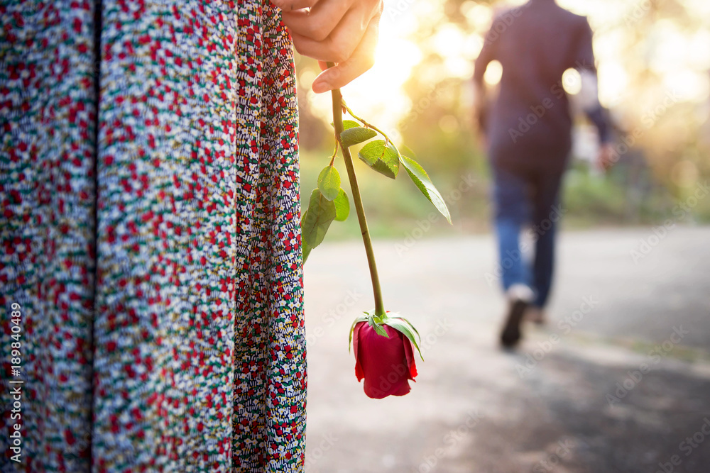 Sadness Love in Ending of Relationship Concept, Broken Heart Woman Standing  with a Red Rose on Hand, Blurred Man in Back Side Walking away as background  Stock Photo | Adobe Stock