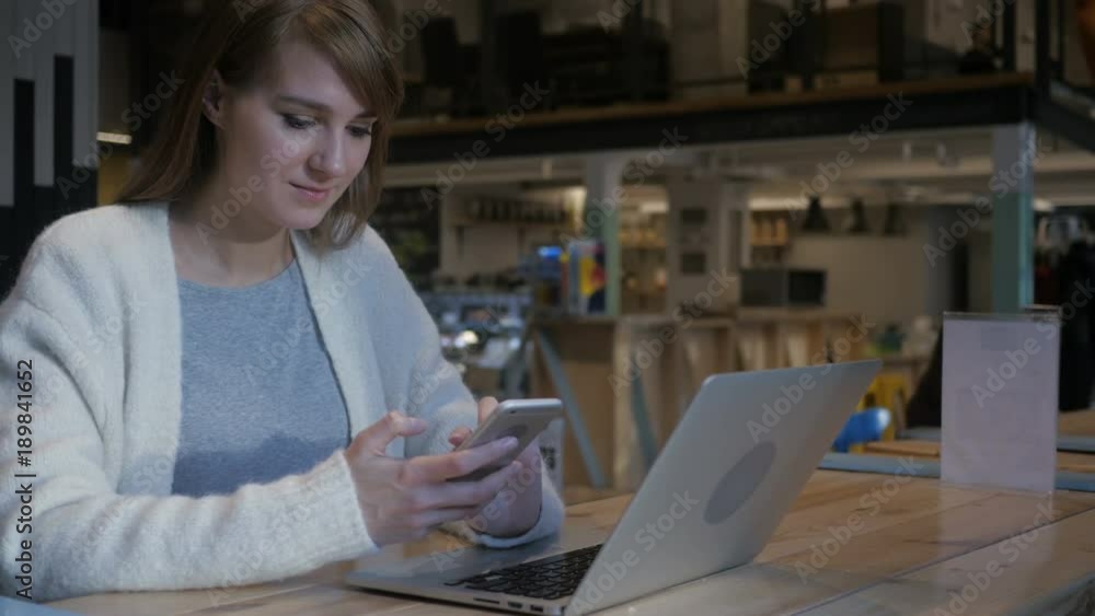 Young Woman Using Smartphone in Cafe, Typing SMS Young Woman Using Smartphone in Cafe, Typing SMS