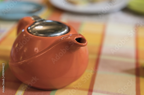 Orange brewer, stands on a table covered with a checkered tablecloth