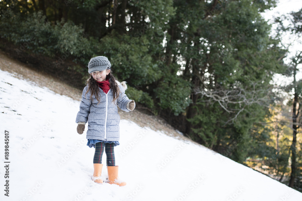 雪の積もった斜面で遊ぶ女の子