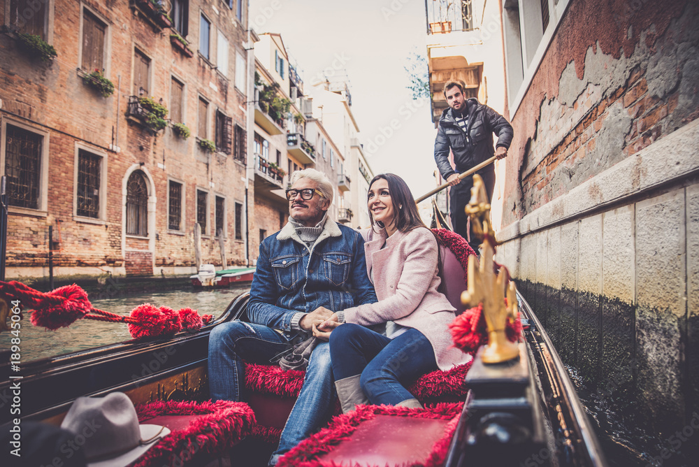Couple sailing on venetian gondola Couple sailing on venetian gondola