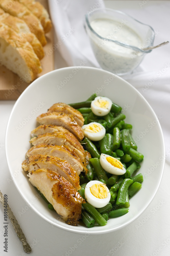 Roasted chicken breasts served with fried egg and boiled green beans. Roasted chicken breasts served with fried egg and boiled green beans.