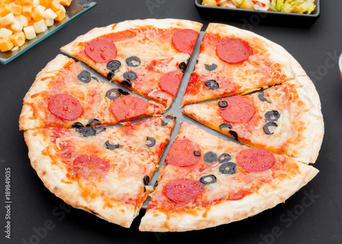 chorizo pizza on modern textured black background