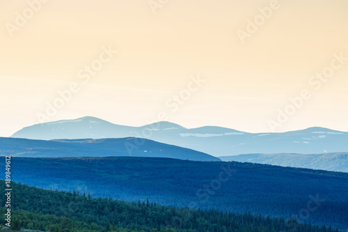 Forest and mountain silhouettes with shadows in evening light