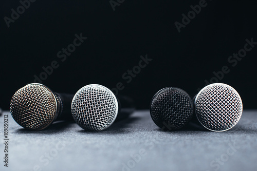 Gray on the table are microphones next to the remote, all on a black background