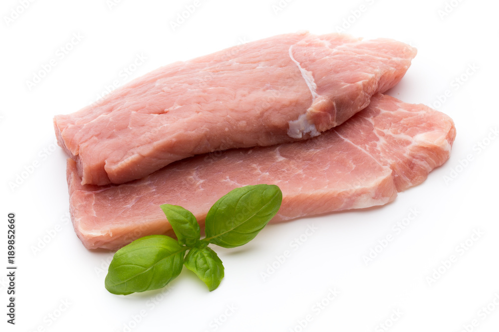 Fresh pork fillet with basil on a white background.