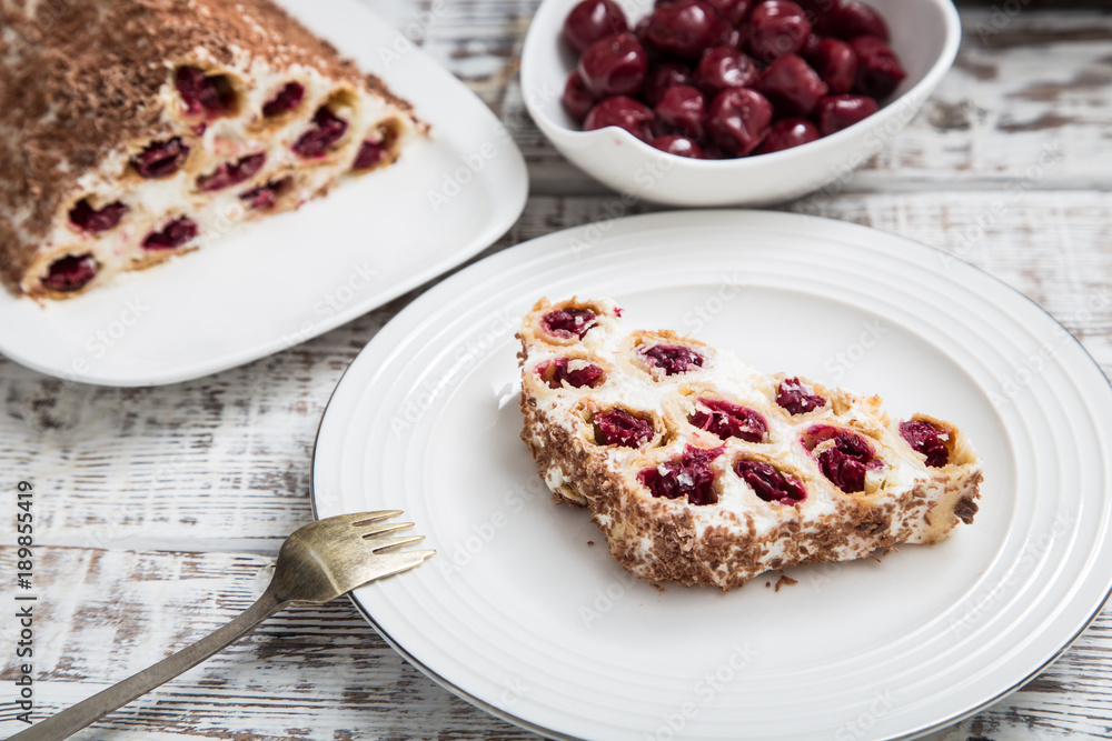 cake with cherries, cream and chocolate on a light wooden background cake with cherries, cream and chocolate on a light wooden background
