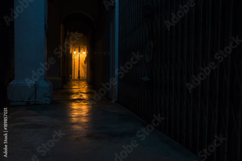 Empty dark street at night with light of latern shining through arches  Georgetown  Penang  Malaysia