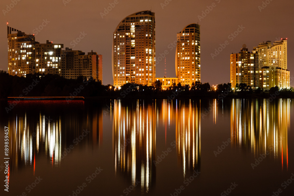 Fototapeta premium night city with reflection of houses in the river