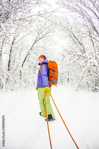 The girl is carrying a sled.