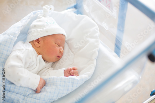 Quadro su tela Newborn baby laying in crib in prenatal hospital