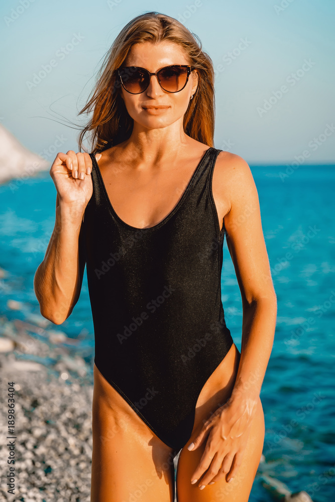Attractive tan woman in swimsuit on tropical beach, resort fashion style. Attractive tan woman in swimsuit on tropical beach, resort fashion style.