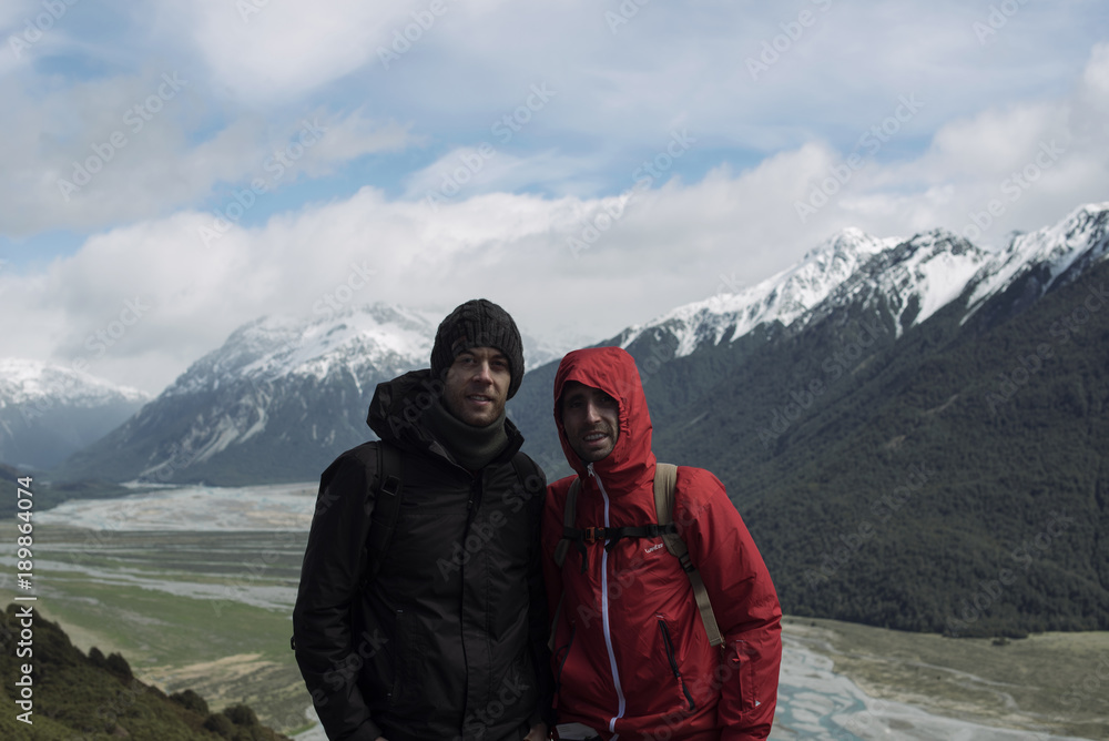Dos chicos jóvenes posando frente a un paisaje de montaña en la naturaleza