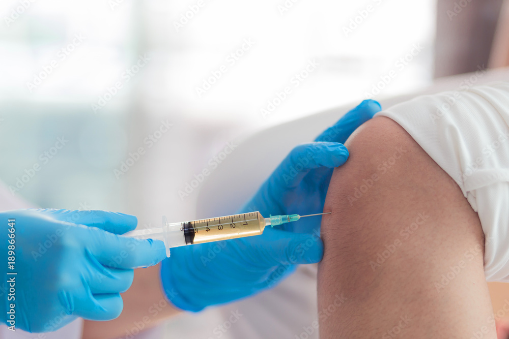 Knee joint aspiration, Hand in blues glove take a joint knee fluid sample in the hospital. Knee joint aspiration, Hand in blues glove take a joint knee fluid sample in the hospital.