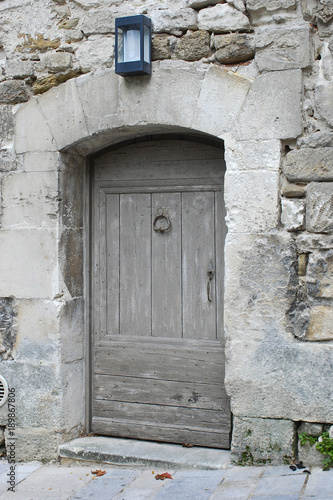 Vintage wooden door in a stone wall. Close up. © demanescale