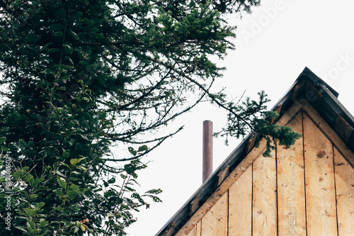 Wooden travel house with a pipe in a summer forest