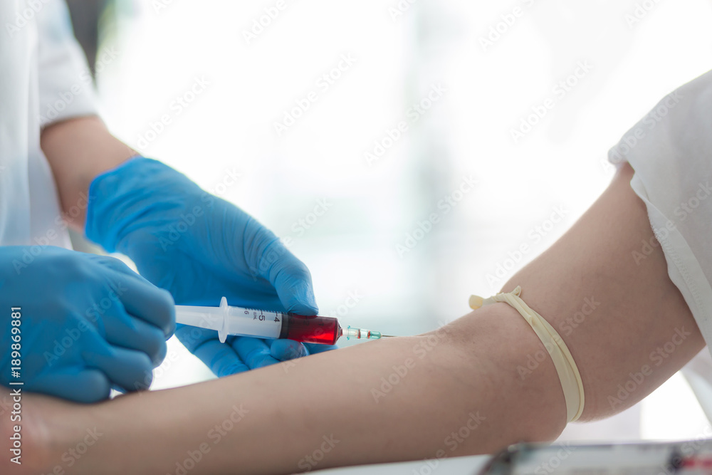 Close up Hand of nurse, doctor or technician in blue gloves taking blood sample from a patient in the hospital. Close up Hand of nurse, doctor or technician in blue gloves taking blood sample from a patient in the hospital.