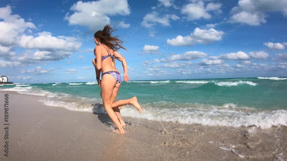 Young couple on vacation running on a sandy beach Young couple on vacation running on a sandy beach