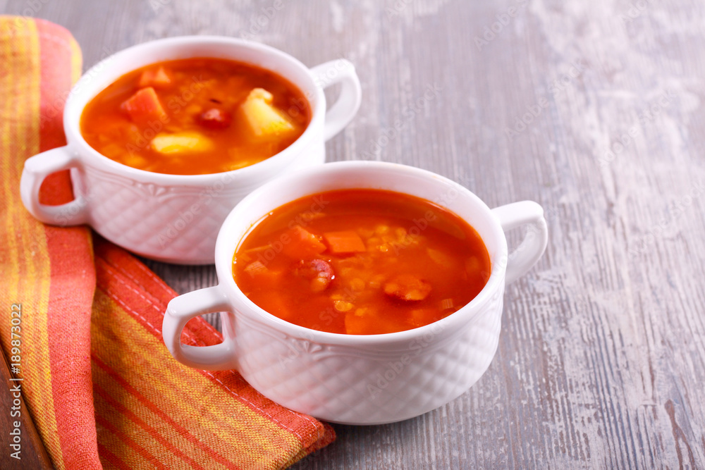 Sausage and red lentil soup, in bowls Sausage and red lentil soup, in bowls