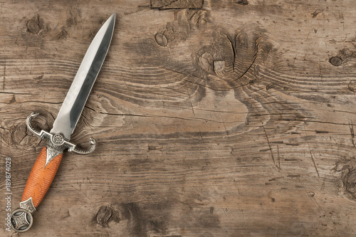 Knife, dagger on a wooden surface, with a place for your text.