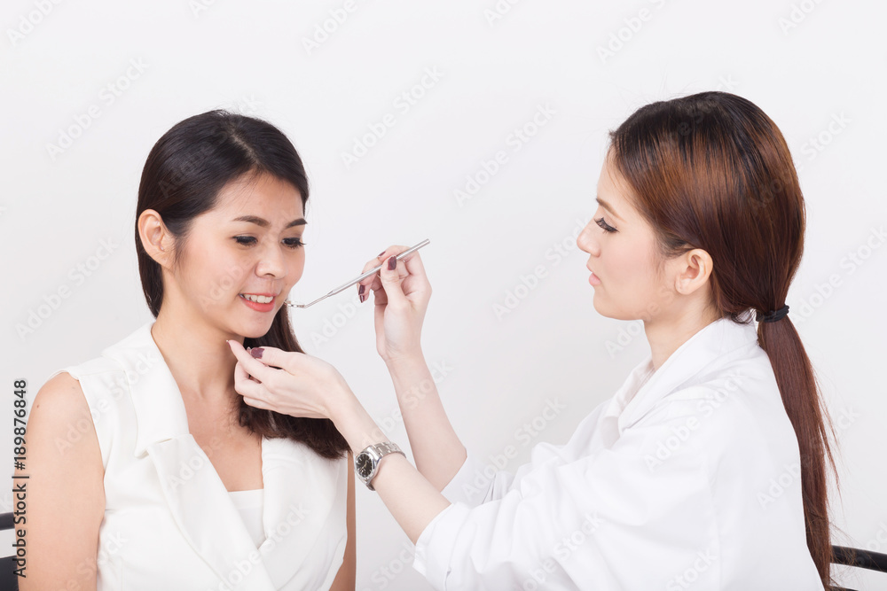 Female doctor checking a patient's teeth. Female doctor checking a patient's teeth.