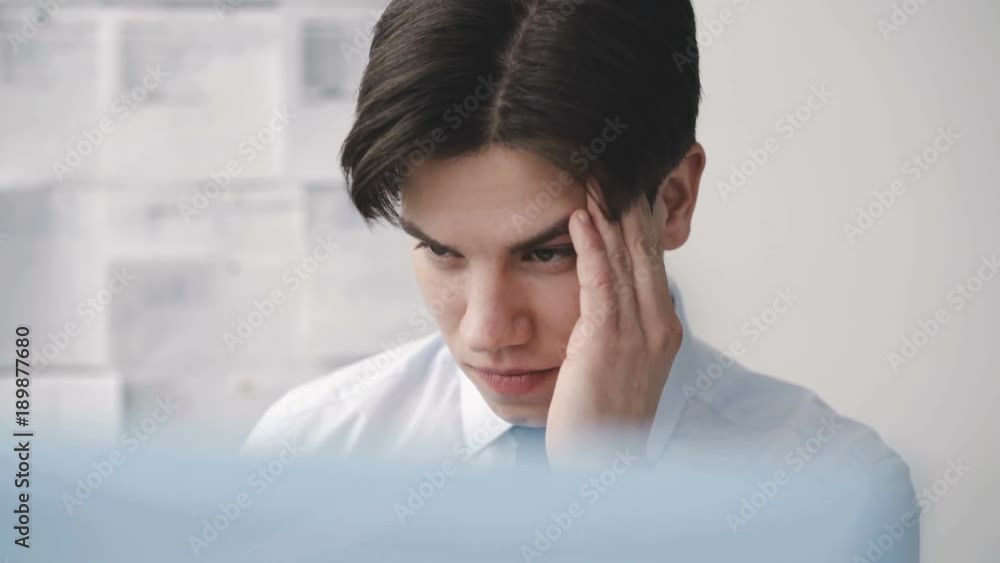 Tired thoughtful man working deligently with pc in office. 4K Tired thoughtful man working deligently with pc in office. 4K