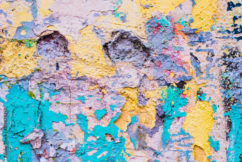 Concrete wall with remains of paint of different colors - grunge texture  background