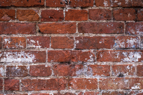 Old vintage brick wall with the remains of paint - grunge texture, background