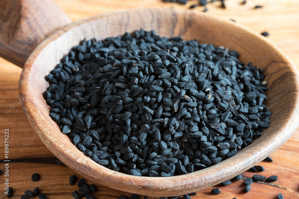 Black cumin seeds on a wooden background Black cumin seeds on a wooden background