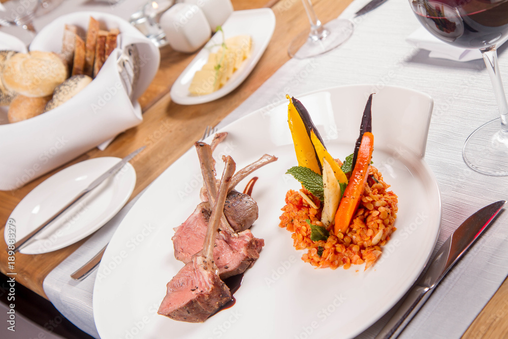 Lamb chops, braised lentils with mint, roast vegetables and rosemary sauce served in a restaurant Lamb chops, braised lentils with mint, roast vegetables and rosemary sauce served in a restaurant