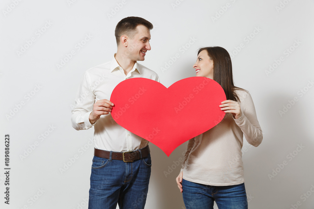 Couple in love. Man and woman with big red heart isolated on white background. Copy space for advertisement. With place for text. St. Valentine's Day International Women's Day birthday holiday concept Couple in love. Man and woman with big red heart isolated on white background. Copy space for advertisement. With place for text. St. Valentine's Day International Women's Day birthday holiday concept