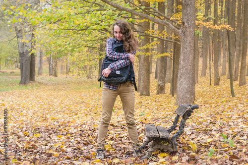 Happy srudent embraces a backpack in the autumn park. Education, lifestyle and people concept. photo