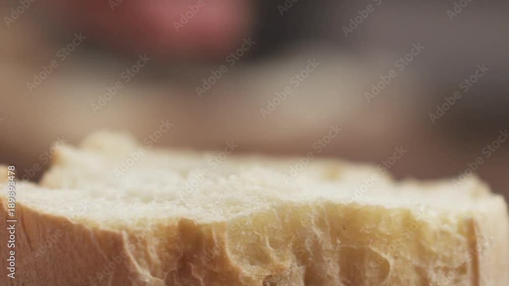 Slow motion closeup of spreading cream cheese on fresh baguette slice Slow motion closeup of spreading cream cheese on fresh baguette slice