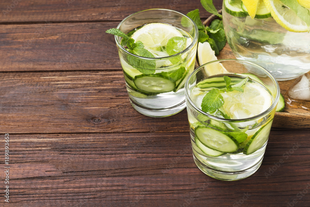 Detox drink with cucumber, lemon and mint in glasses on a wooden background. Copy space. Food background Detox drink with cucumber, lemon and mint in glasses on a wooden background. Copy space. Food background
