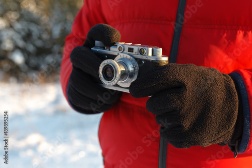 Vintage camera in hand, outdoor winter with sky photo